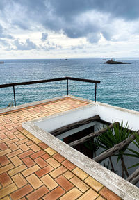 View of swimming pool by sea against sky