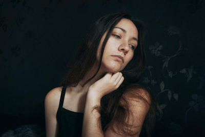 Young woman against black background