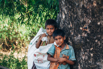 Portrait of a smiling girl holding tree