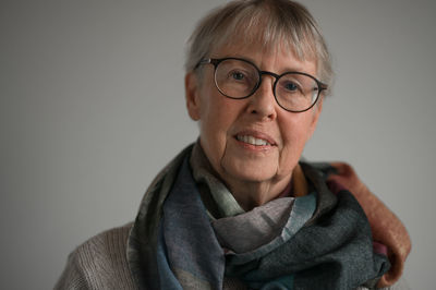 Portrait of old woman against gray background