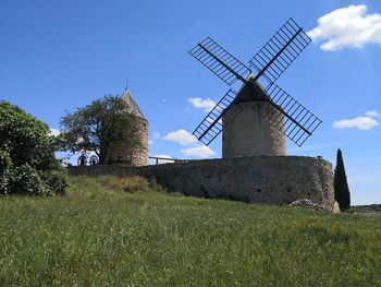 Traditional windmill on field against sky