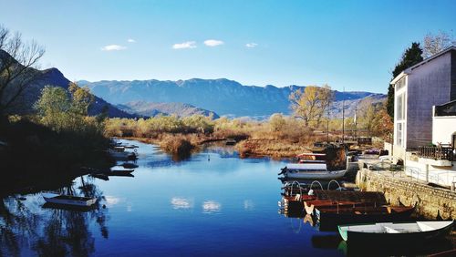 Scenic view of lake and mountains against clear blue sky