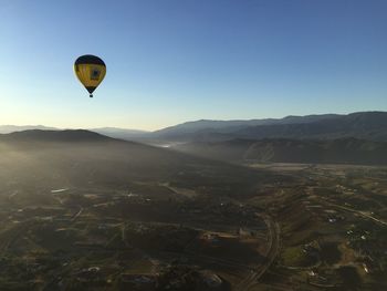 Hot air balloons flying over landscape against sky