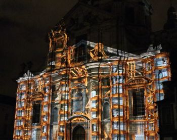 Low angle view of illuminated building against sky at night