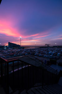 Scenic view of sea by buildings against sky during sunset