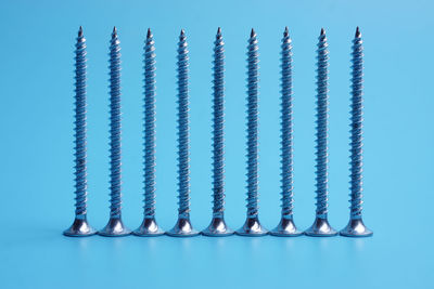 Close-up of screws over blue background