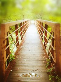 Footbridge amidst wooden railing