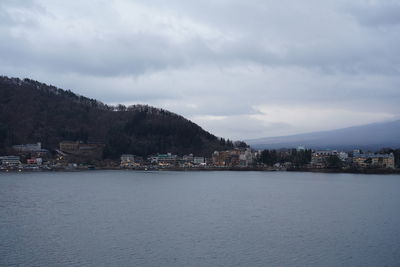 Scenic view of sea by buildings against sky