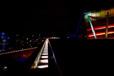 Illuminated city buildings against clear sky at night