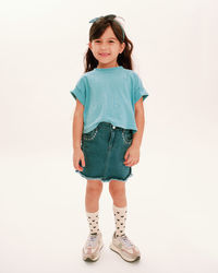 Portrait of young woman standing against white background