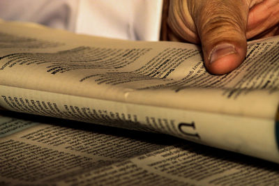 Close-up of cropped hand holding newspaper