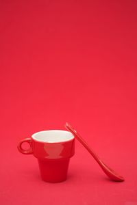 Close-up of coffee cup against red background