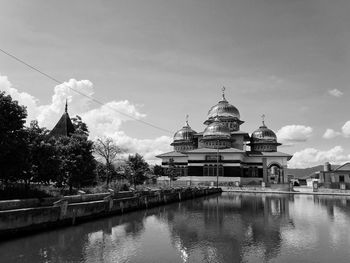 View of mosque and building against sky