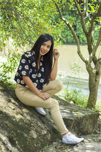 Young woman sitting on tree