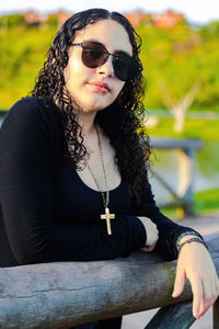 Young woman wearing sunglasses sitting outdoors
