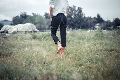 Low section of man walking on field