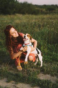 Beautiful woman plays with her jack russell dog in the park.