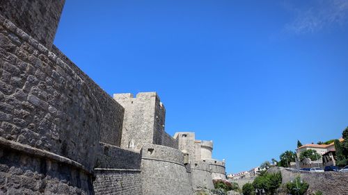 Low angle view of historic building against blue sky