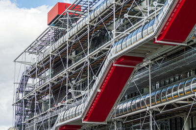 Low angle view of red staircase by building against sky