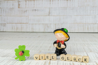 Close-up of figurine with toy blocks on wooden table