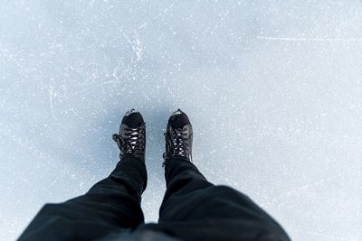 Low section of man standing on ice rink during winter