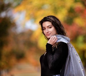 Portrait of beautiful young woman standing during autumn