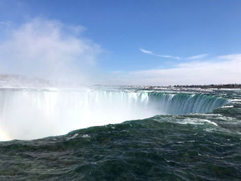 Scenic view of waterfall against sky