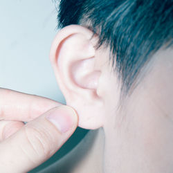 Cropped image of woman touching ear