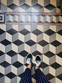 Low section of woman standing on tiled floor