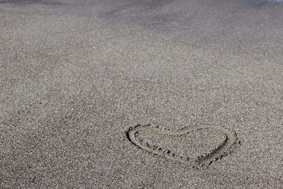 High angle view of heart shape drawn at sandy beach