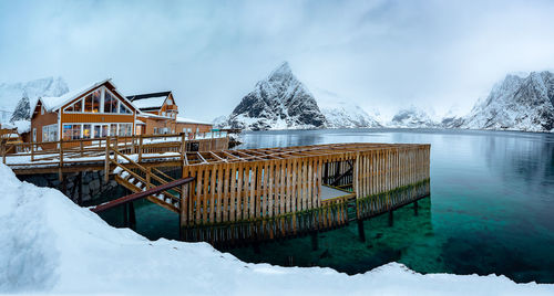 Built structure by frozen lake against sky