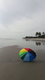 Umbrellas on beach against sky