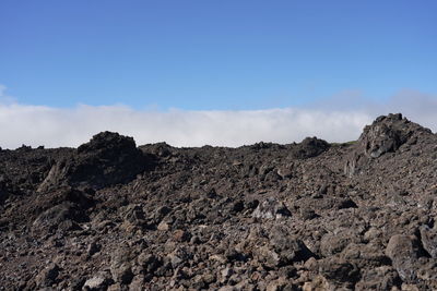 Low angle view of volcanic mountain against sky