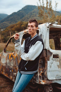 Portrait of teenage girl standing by car