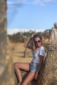 Young woman resting leaning on a rock in the desert