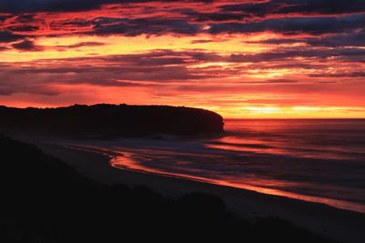 Scenic view of sea against dramatic sky during sunset