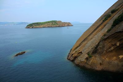 Scenic view of rocks in sea against sky