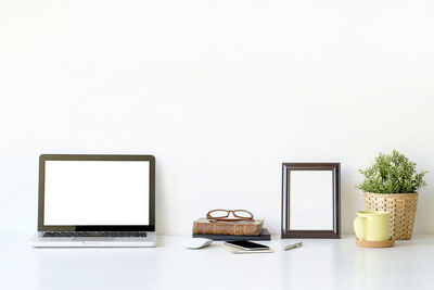 Low angle view of laptop on table against white background