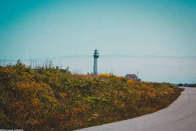 Lighthouse by sea against sky