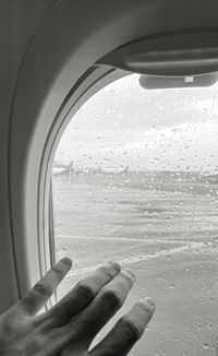 Man seen through wet glass window