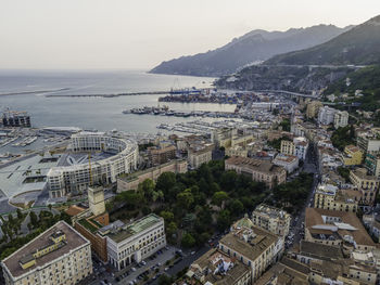 High angle view of townscape by sea against sky