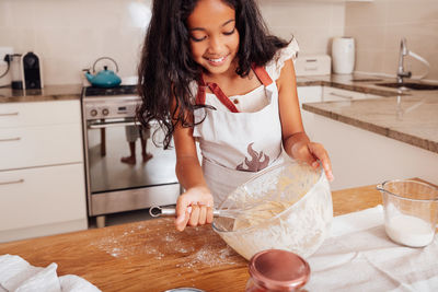 Portrait of young woman preparing food at home