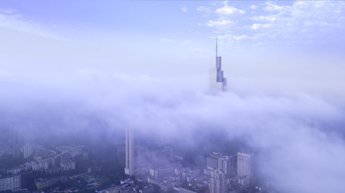 Aerial view of buildings in city against sky