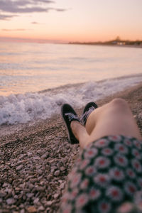 Close-up of woman's legs on the beach at sunset