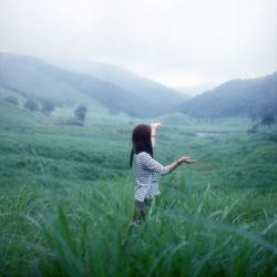 Rear view of man standing on grassy field