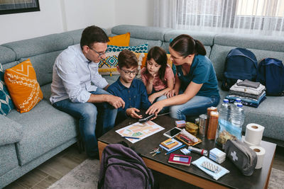 High angle view of people sitting on sofa at home