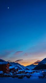 Scenic view of snowcapped mountains against blue sky during sunset