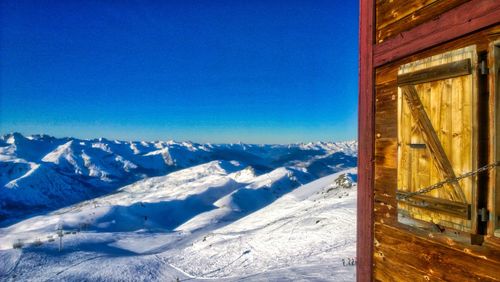 Scenic view of snowcapped mountains against clear blue sky