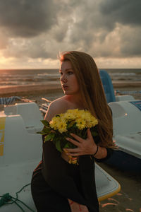 Portrait of young woman holding bouquet