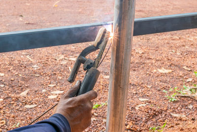 High angle view of man holding metal on field